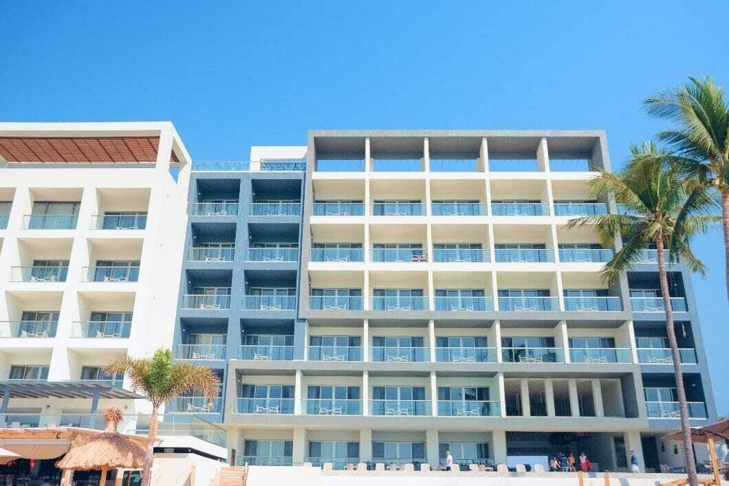 Avenir Armonia Suites: the multi-story building with balconies, the pool area and palm trees